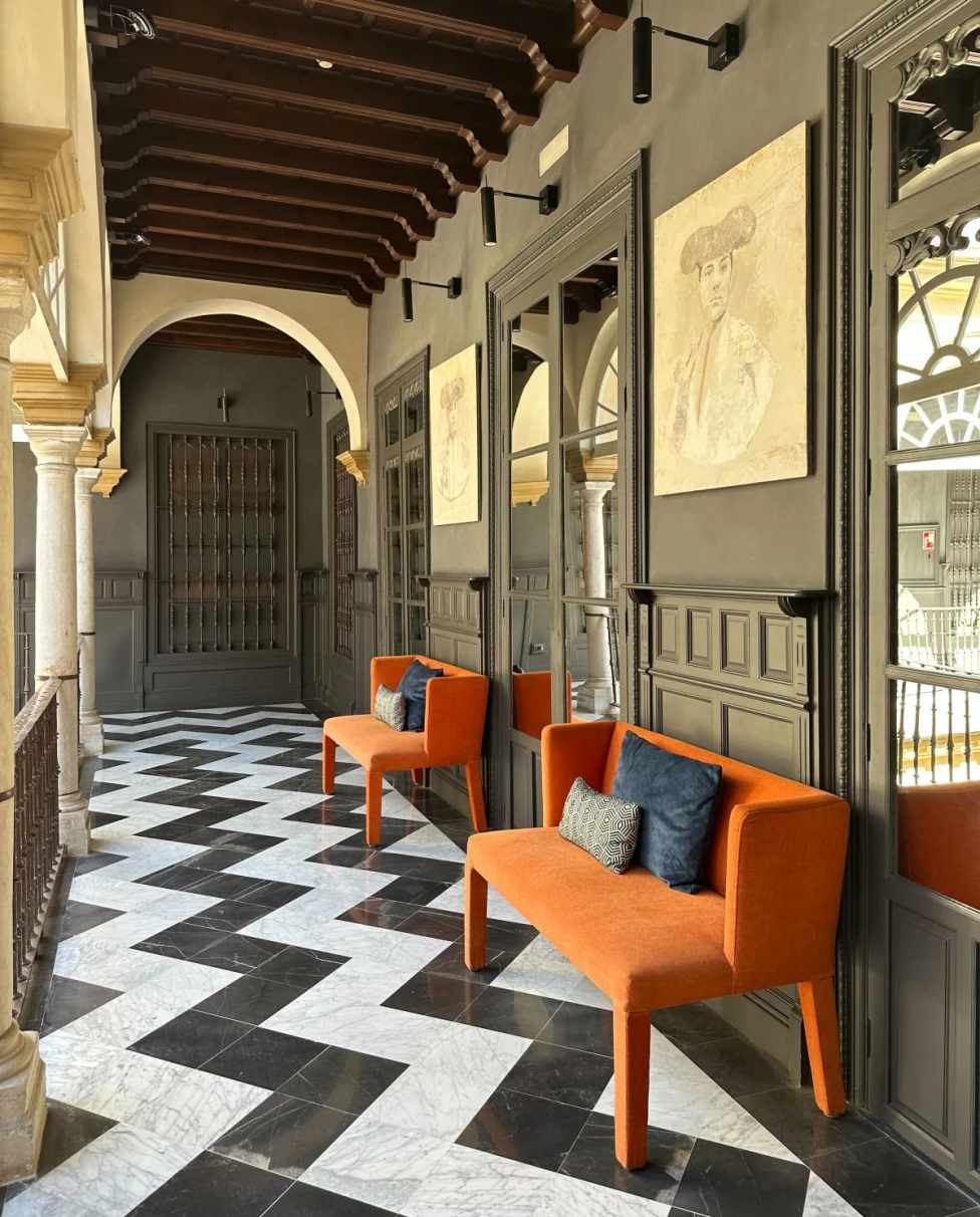 orange couch on a black-and-white checkered floor