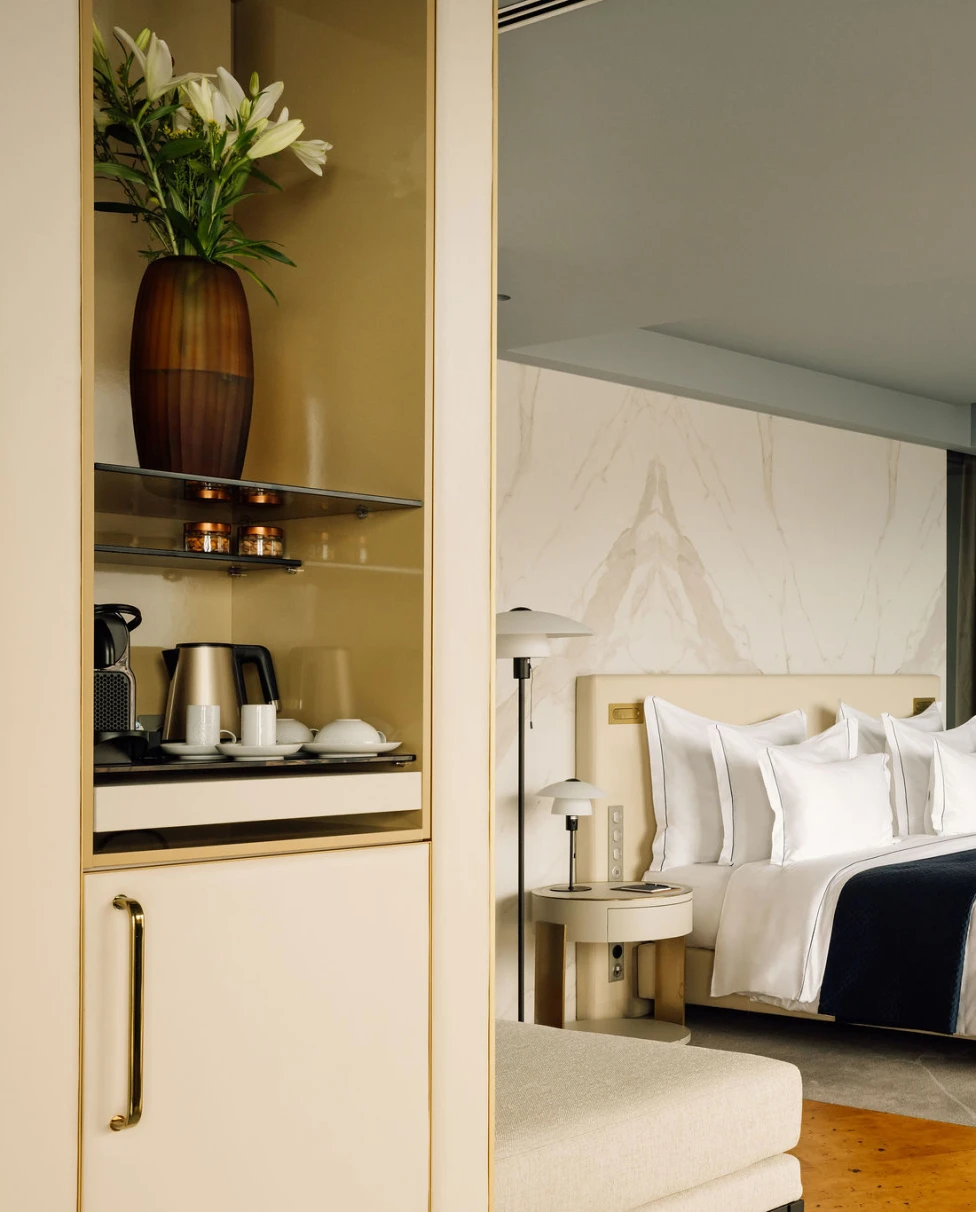 a modern hotel suite with a plush bed and brown cork floors