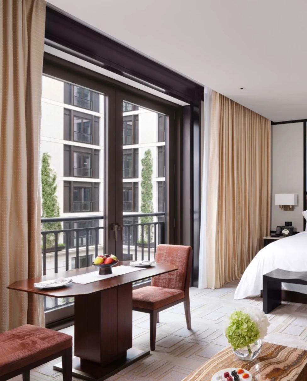 chic hotel room with a white bed and black-bordered floor-to-ceiling windows
