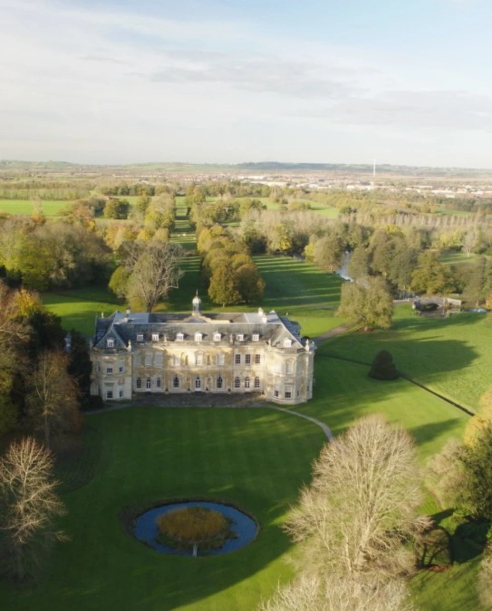 An aerial view of Hartwell House & Spa surrounded by lush grenery with many trees.