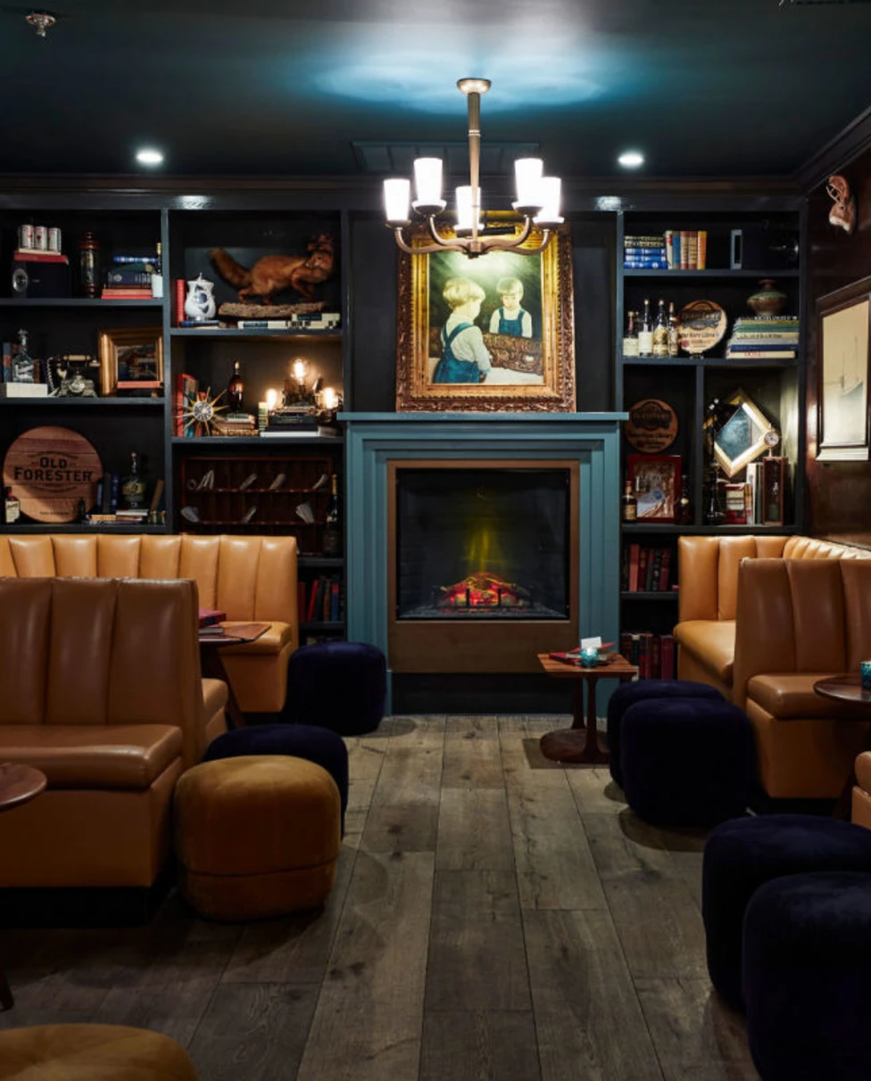 Lounge at the Oliver Hotel in Knoxville. Booths around fireplace with countryside charm.