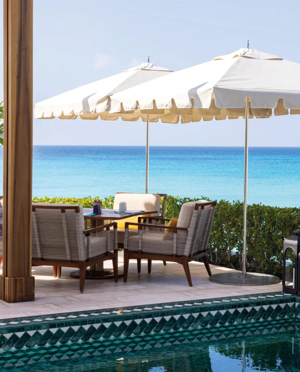 pool and tables overlooking a sea with a sailboat