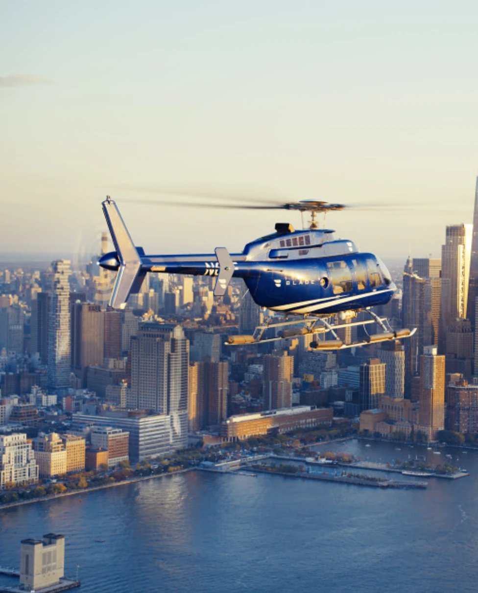 A BLADE helicopter flying over New York at sunset.