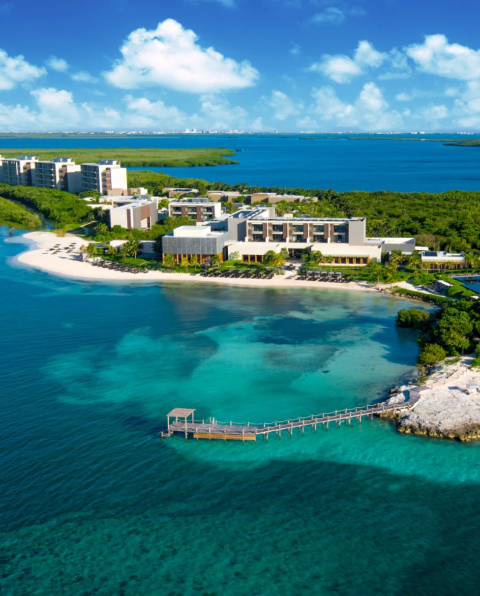 An aerial view of NIZUC Resort & Spa with beautiful beach and lush forest.