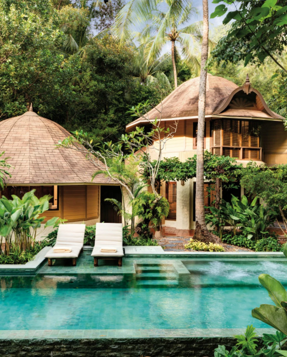 domed buildings overlook a luxe pool in a lush jungle