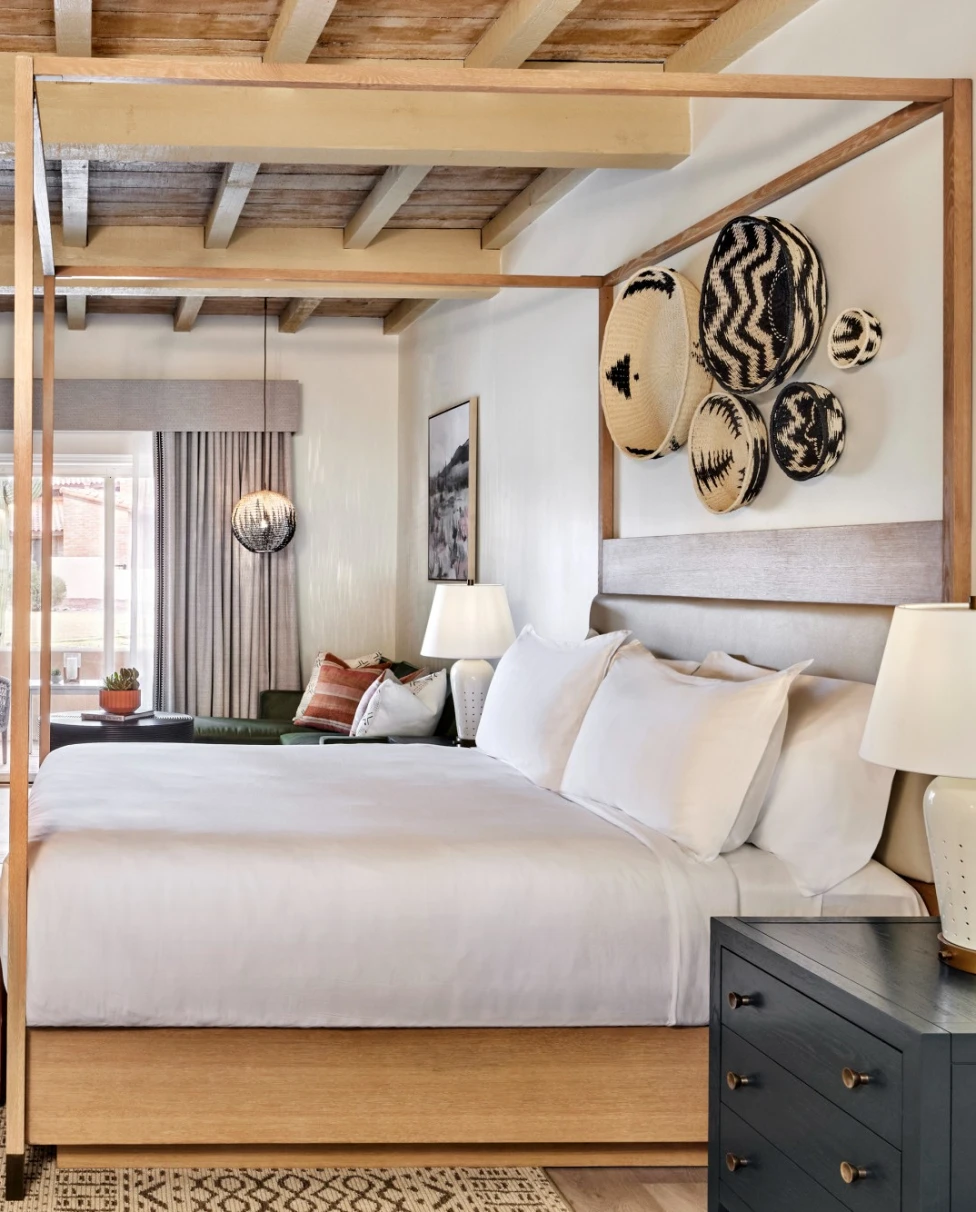 white bed in a hotel room with a fireplace and wooden ceiling beams