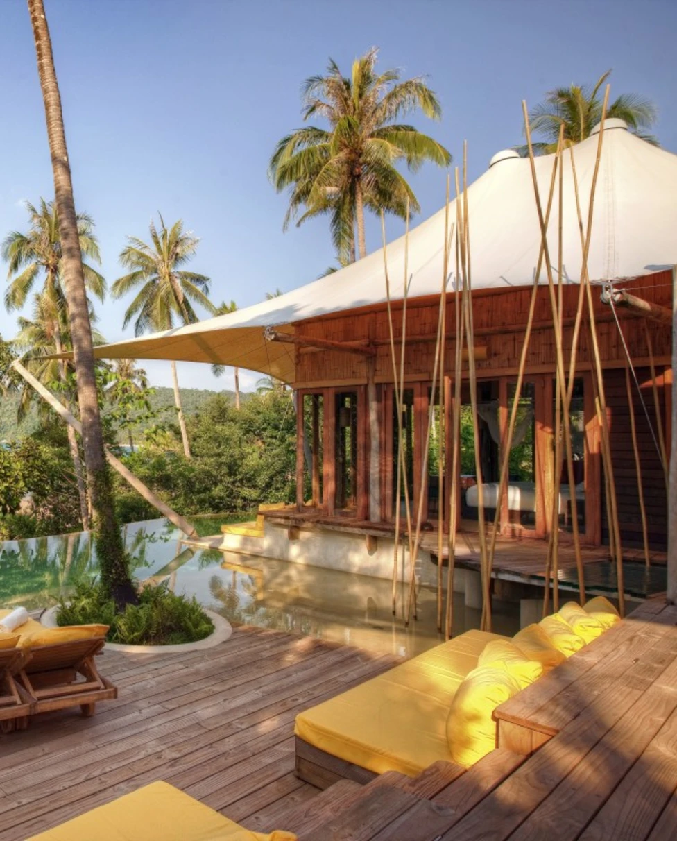 a wooden deck with an infinity pool overlooking the ocean