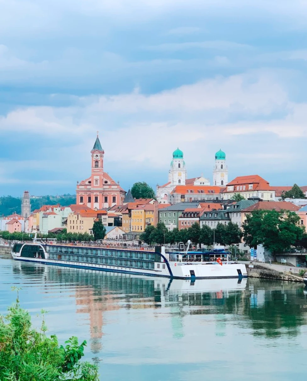 A Long river cruise docked near an old European town