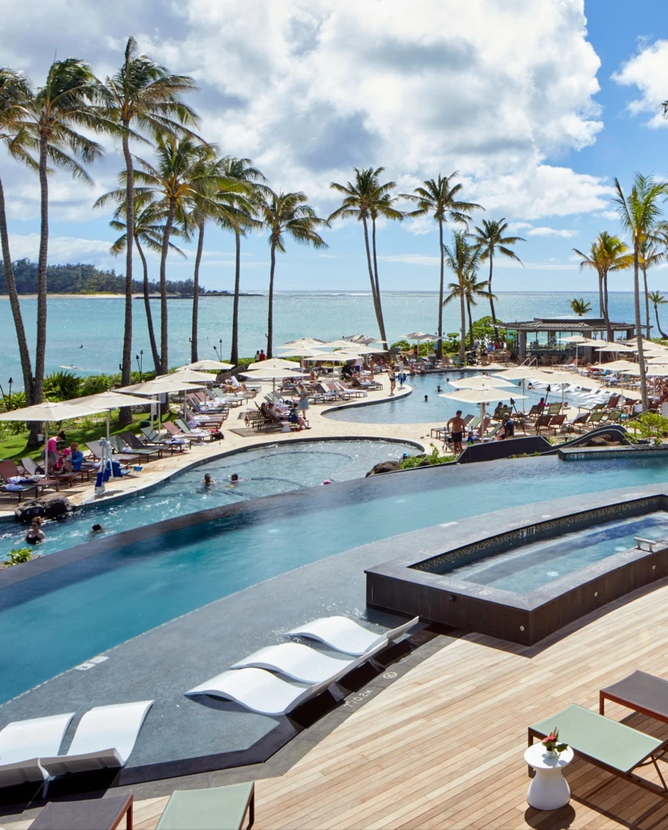 white chairs in an infinity pool overlooking the sea