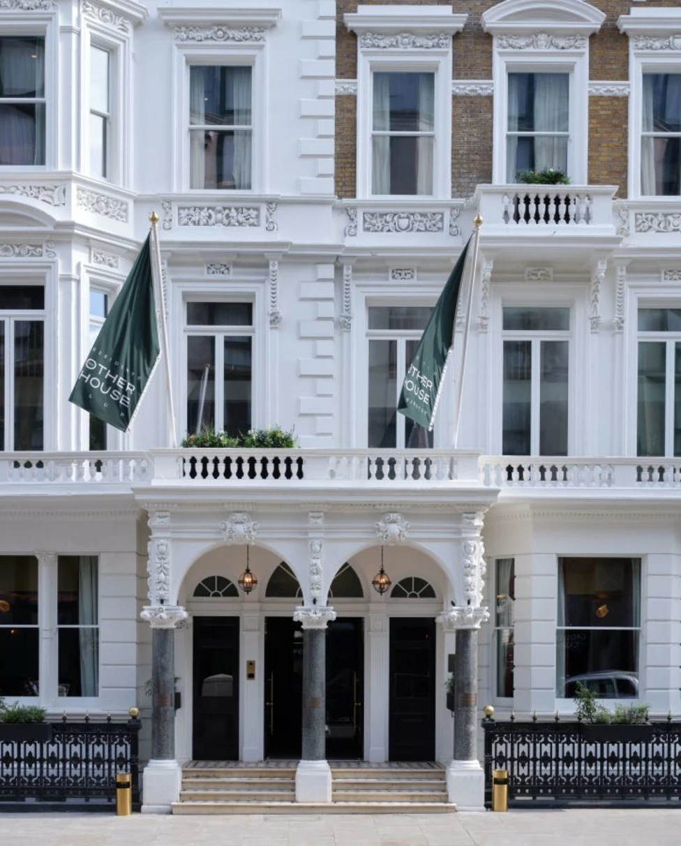 Exterior view of The Other House South Kensington with a grand, white facade and flags flying over the entrance.