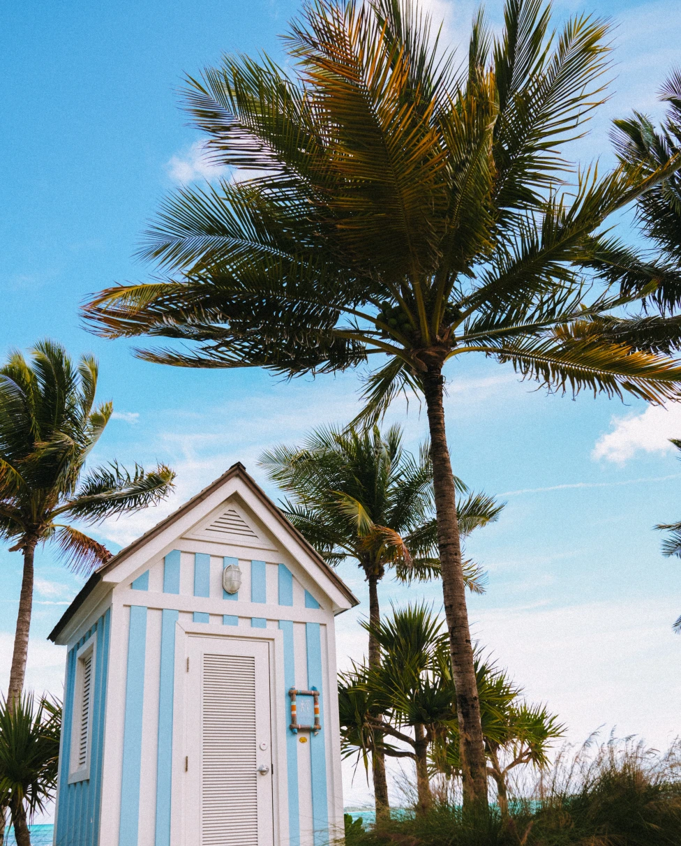 A striped house and palm trees in the Bahamas.