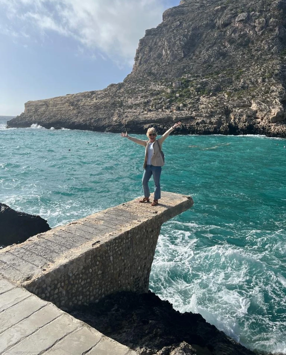 A woman standing and enjoying on deck.