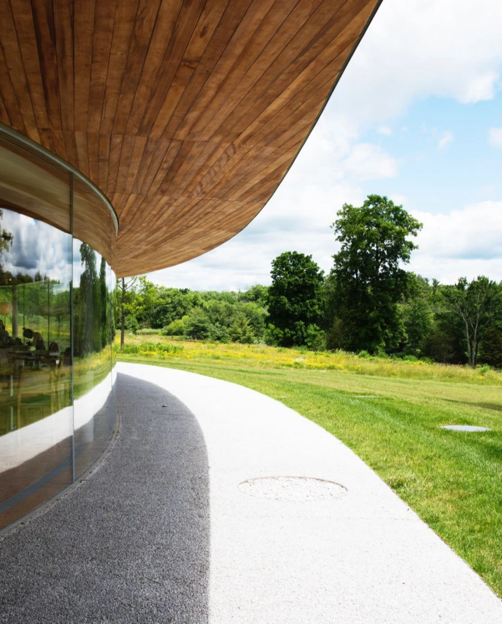 Green field near a circular building with brown shade.