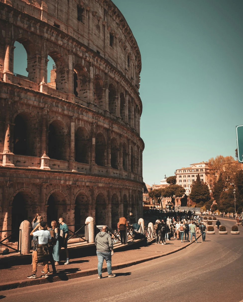People walking and standing near the Colosseum.