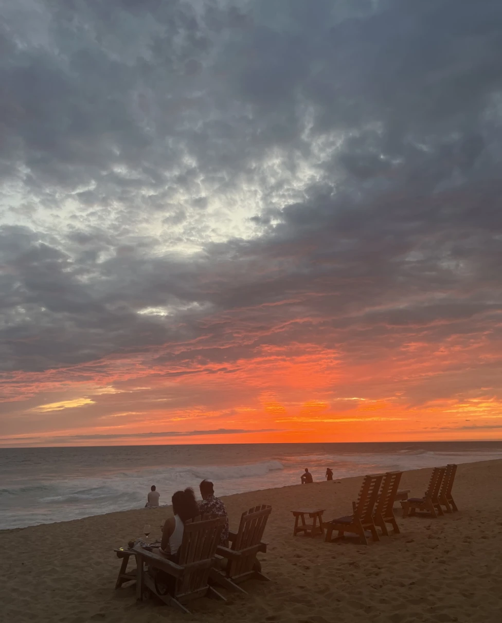 Beach with lounge chairs set up at sunset.