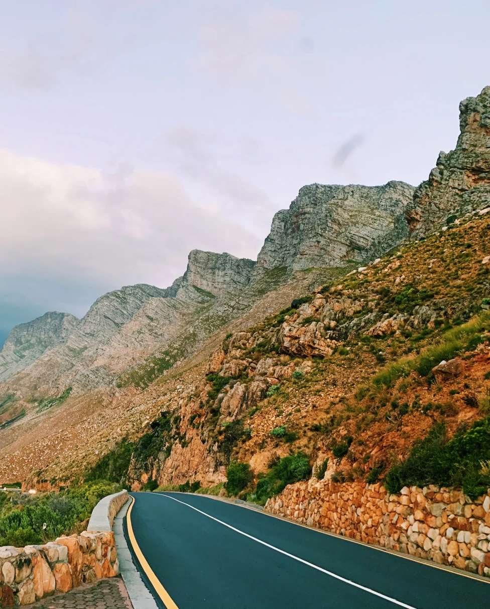Road running alongside the blue ocean and mountains in South Africa