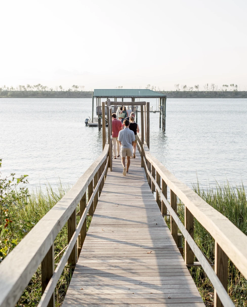 a long dock into a calm bay of water