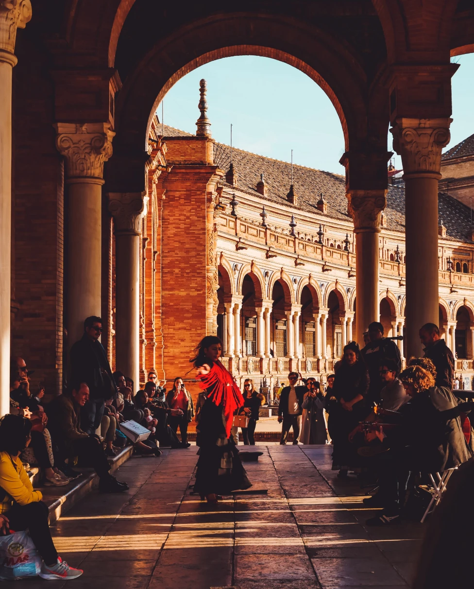 people dancing under a large archway during daytime