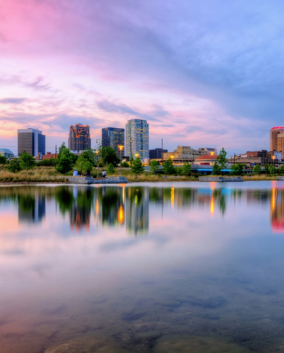 A city reflected in a lake during a blue and purple sunset