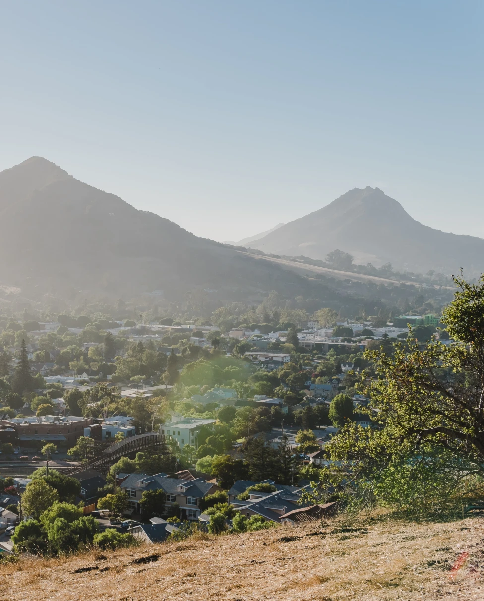 large mountain next to grassy area during daytime