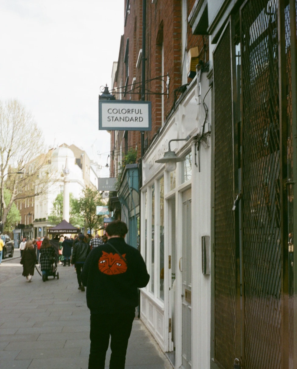 A person walking in the street next to buildings during the daytime