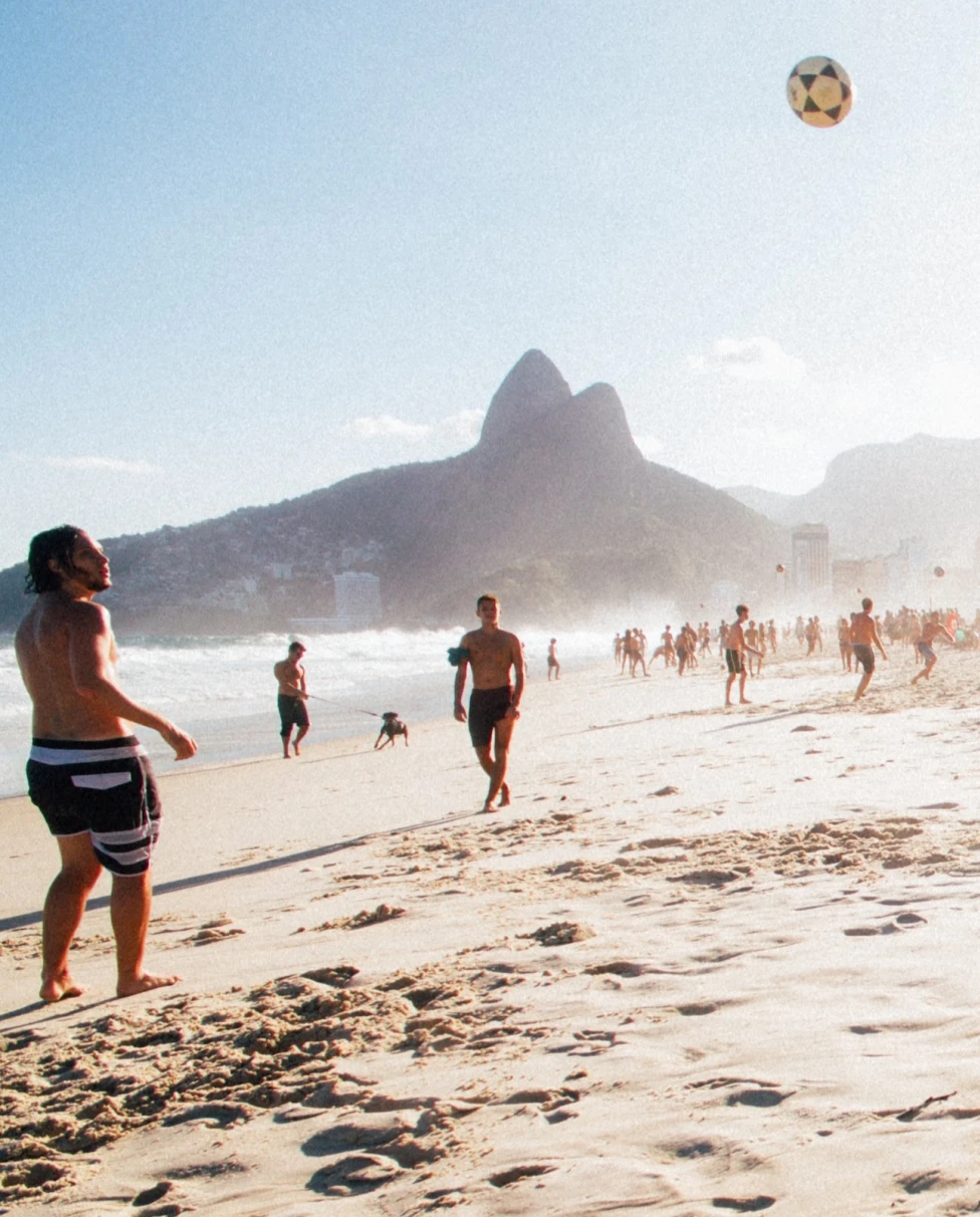 People playing volleyball on the beach.