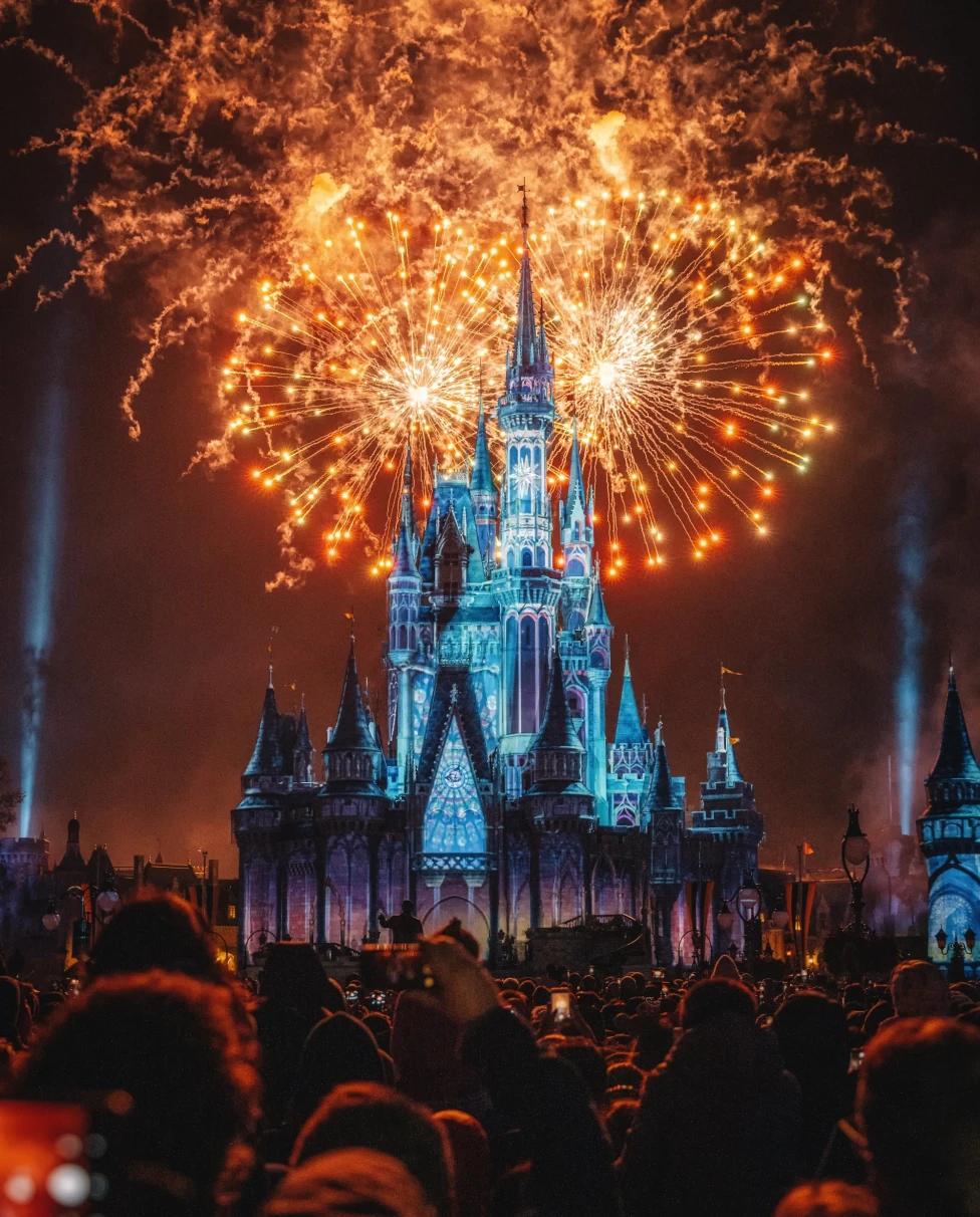 A picture of Disney Castle during the fireworks during the night.