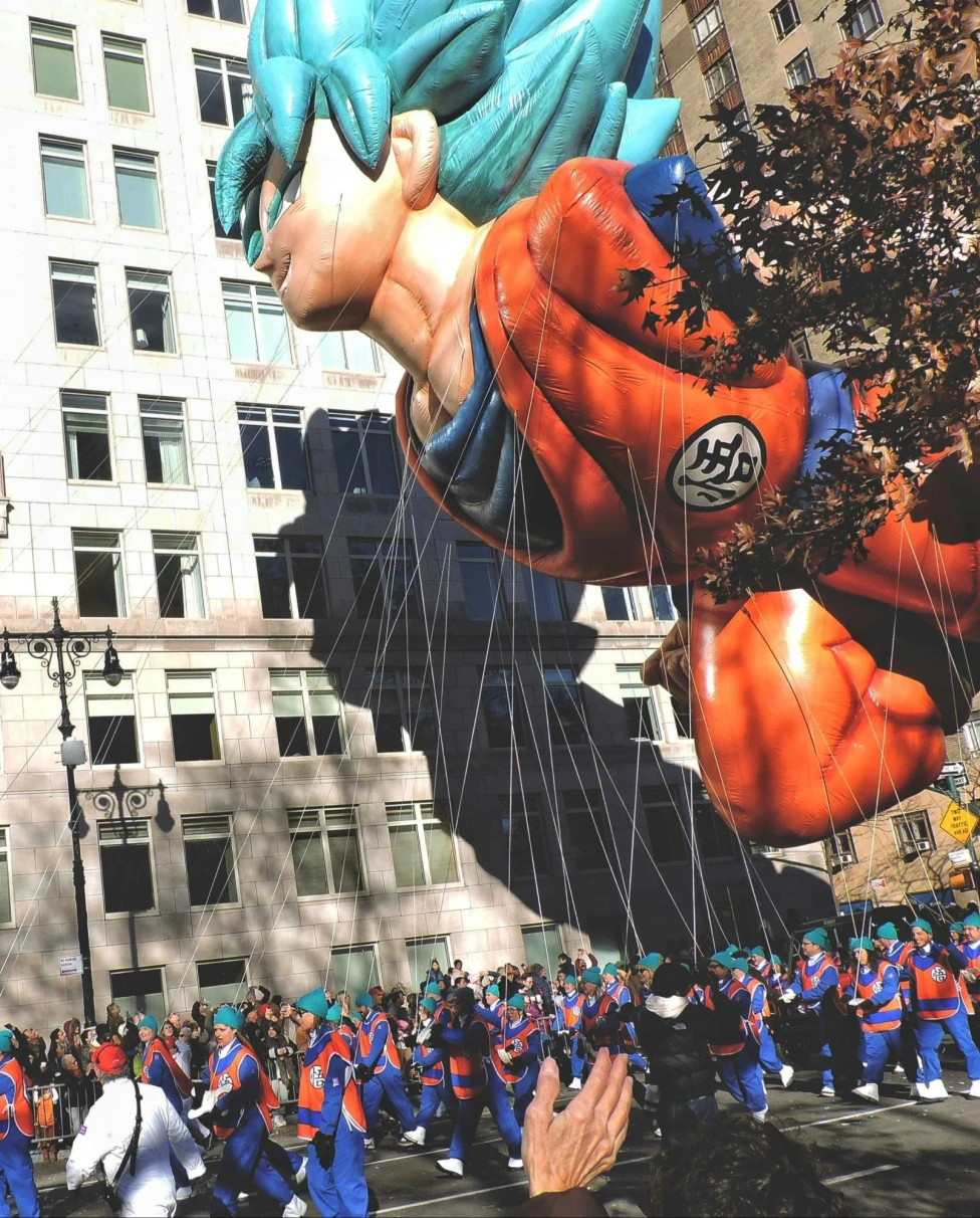 A large balloon in a parade on Thanksgiving.