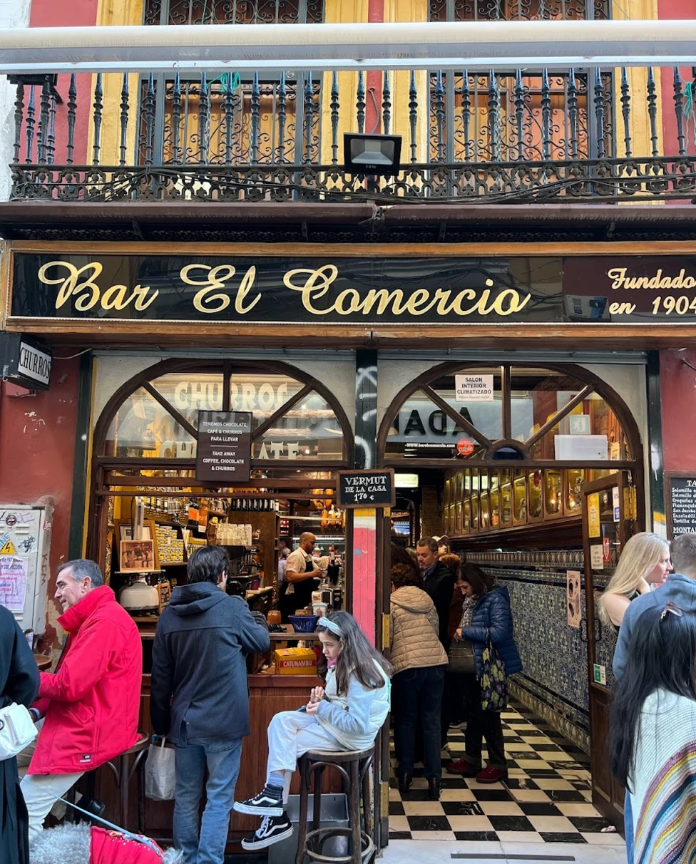 Outdoor sitting with people of a bar named Bar el comercio.