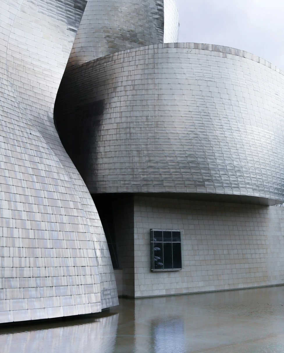 A close-up shot of the curvy architecture of the exterior of the Guggenheim Museum in Bilboa, Spain.