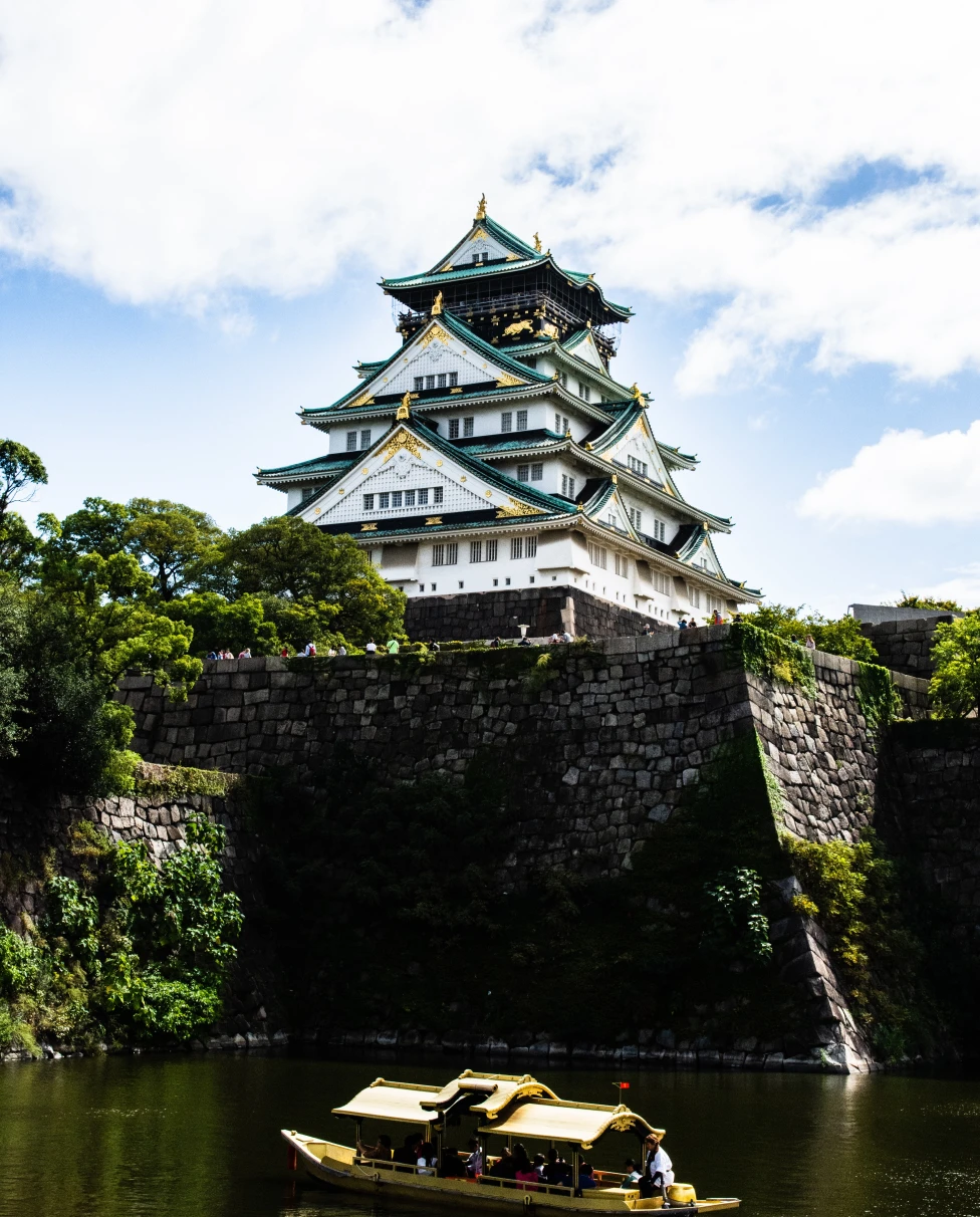 boat in water with temple in the background during daytime