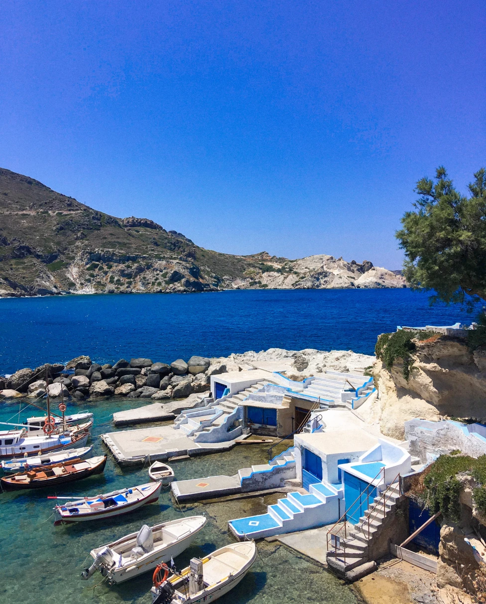 Boats next to small homes and body of water during daytime