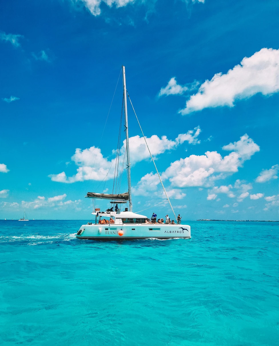 A white boat sailing in a large, blue body of water during the daytime