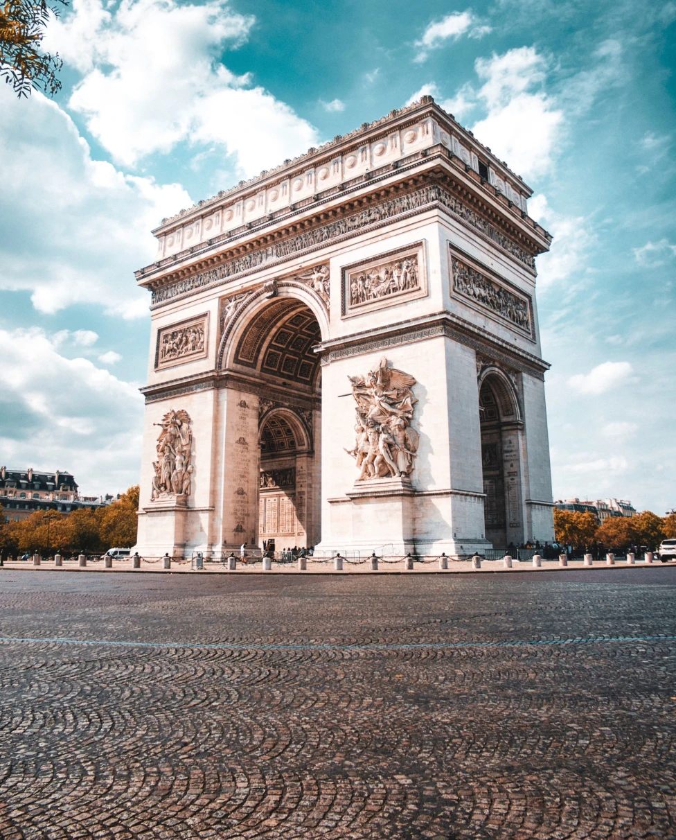 A white concrete arc under blue sky and white clouds during daytime.