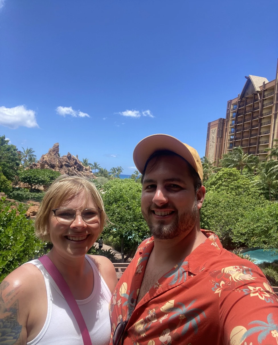 A couple posing in front of Disney's Aulani Resort.