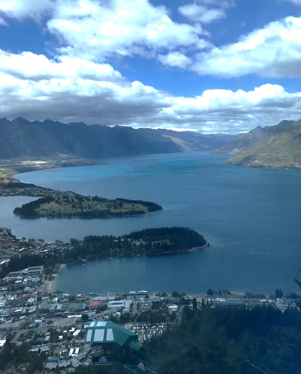 An aerial view of the city and the sea near the mountains during the daytime.