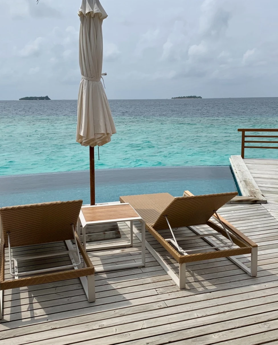 two loungers on a wooden deck overlooking the sea