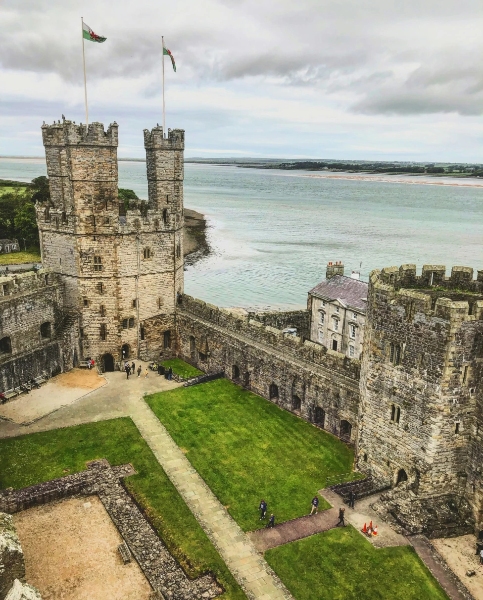 An aerial view of a concrete castle near the water.