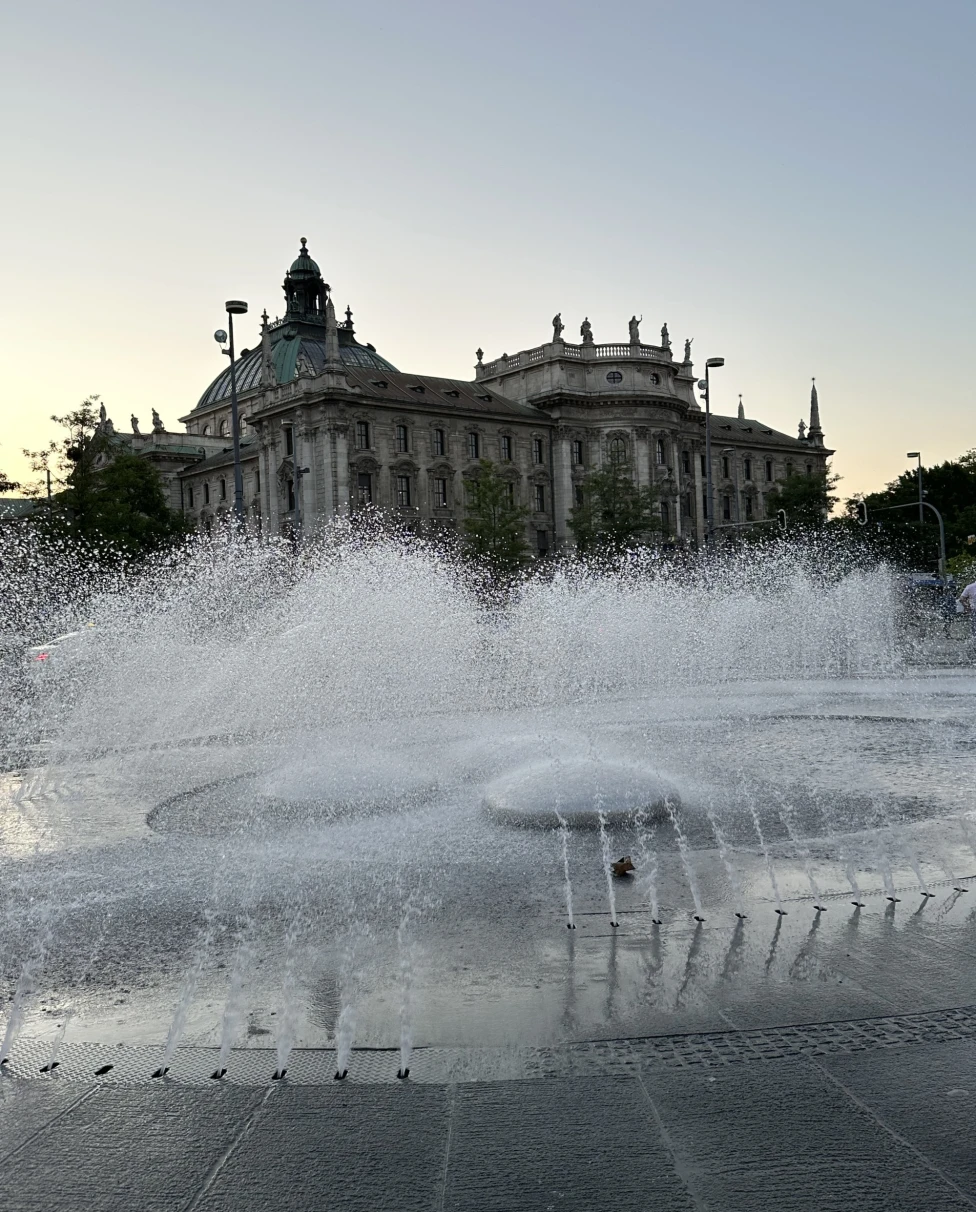 A large fountain in front of an old stone building in Munich, Germany.