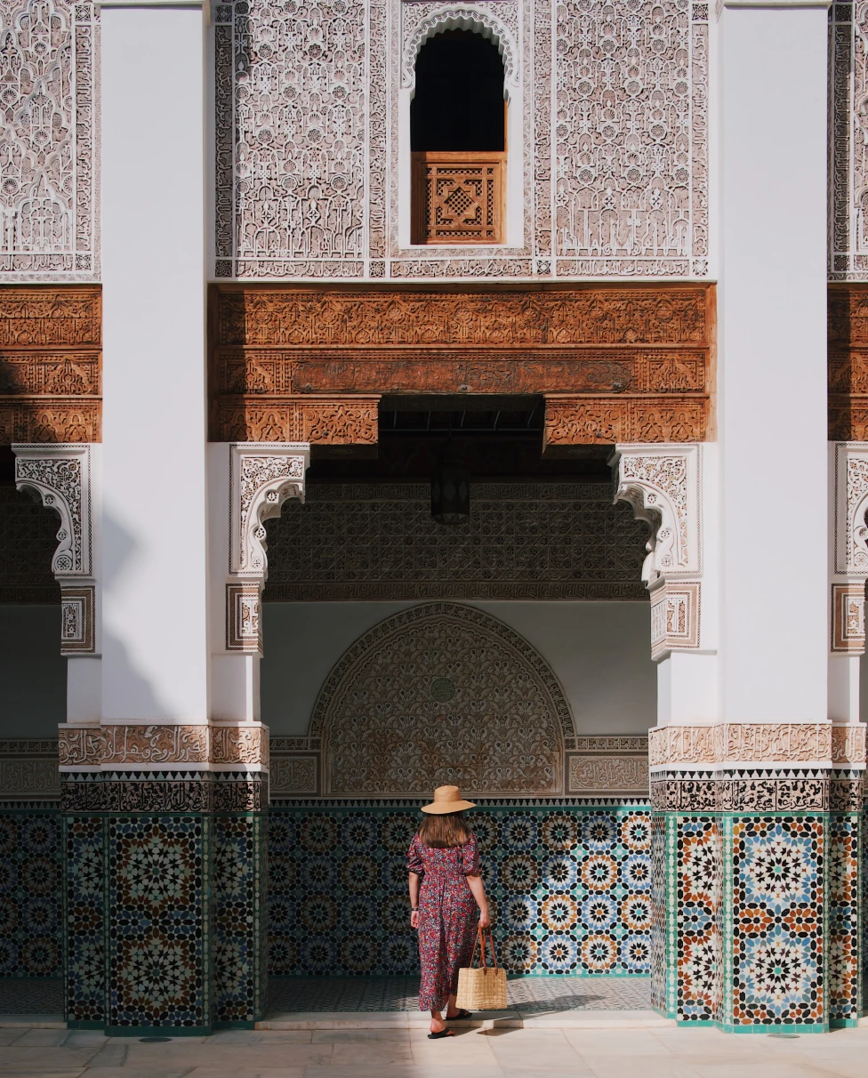 woman standing next to building with colorful tile during daytime