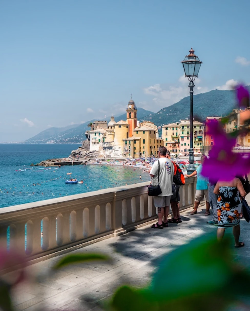 people walking on sidewalk near body of water during daytime