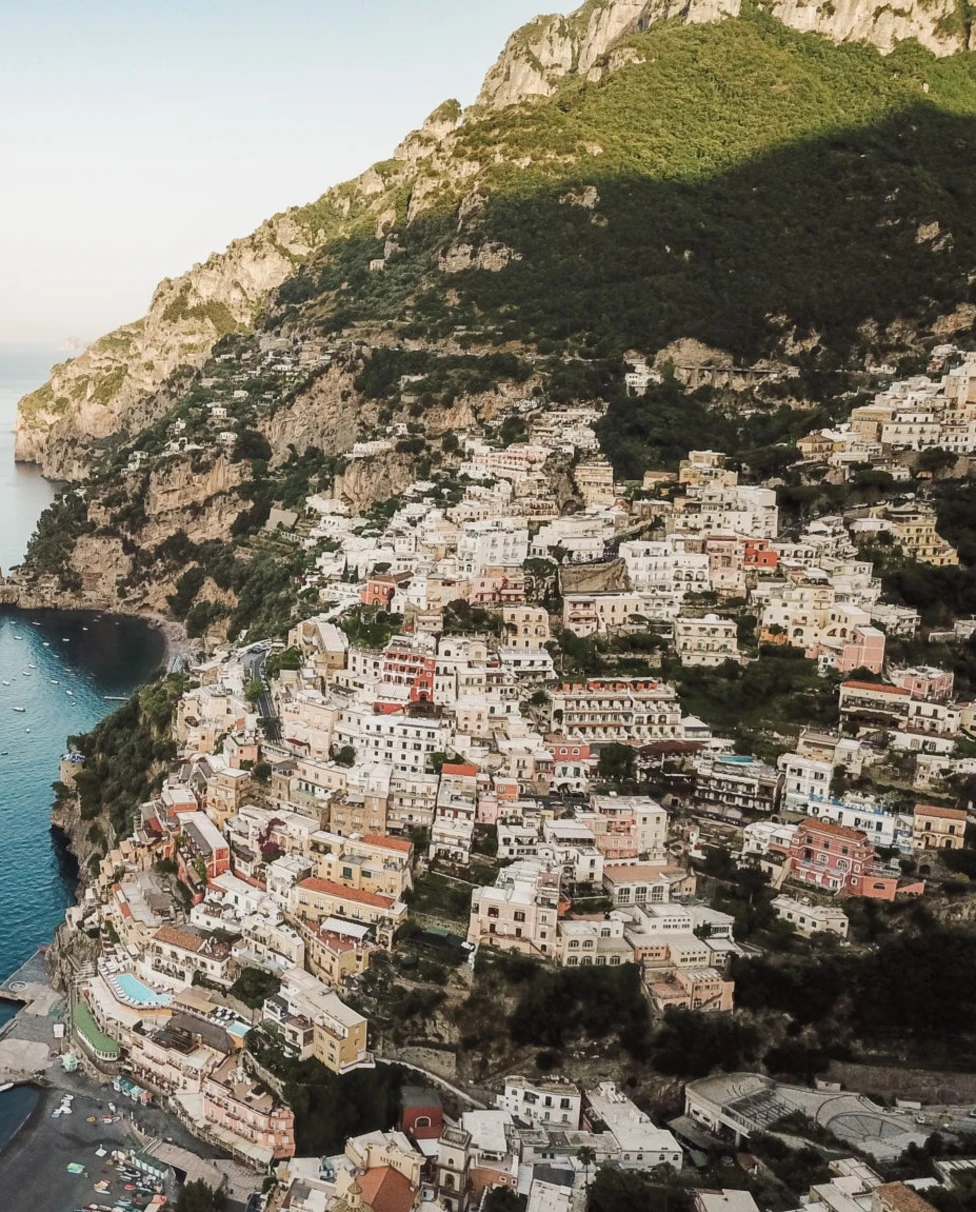 This aerial view shows tiny colorful buildings in the cliffside of Positano.