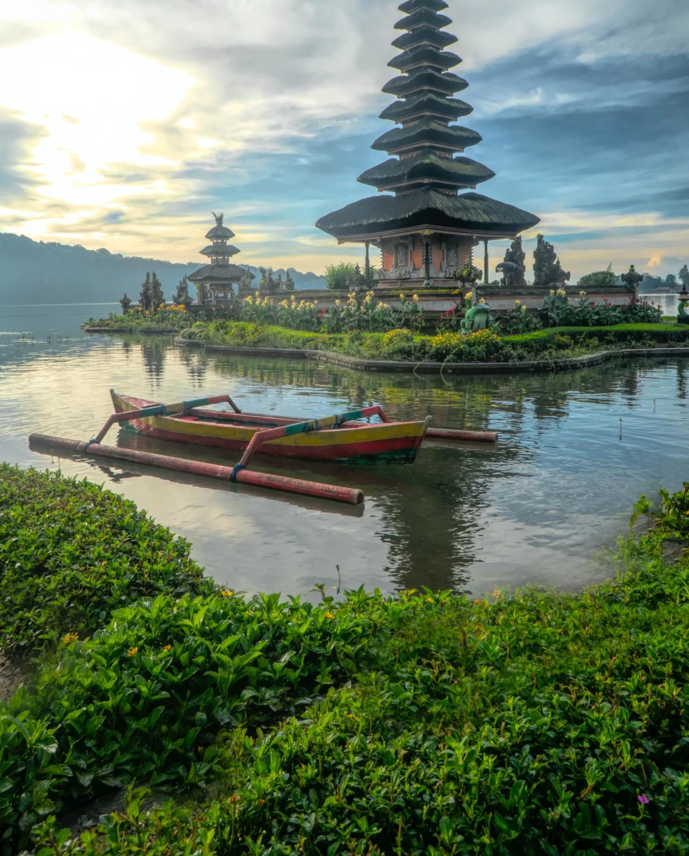 Canoe on body of water with pagoda background.