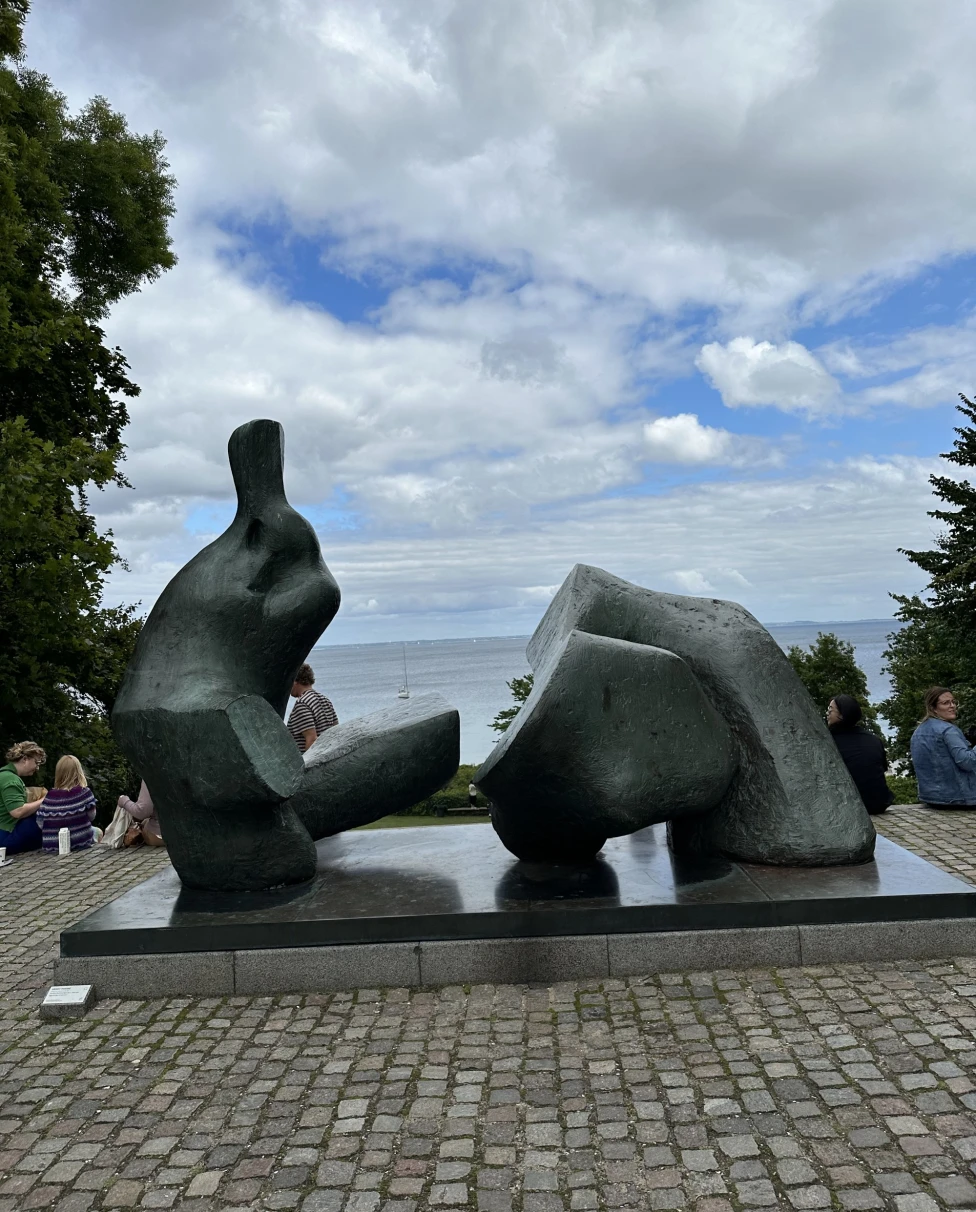 A grey landmark with people around.