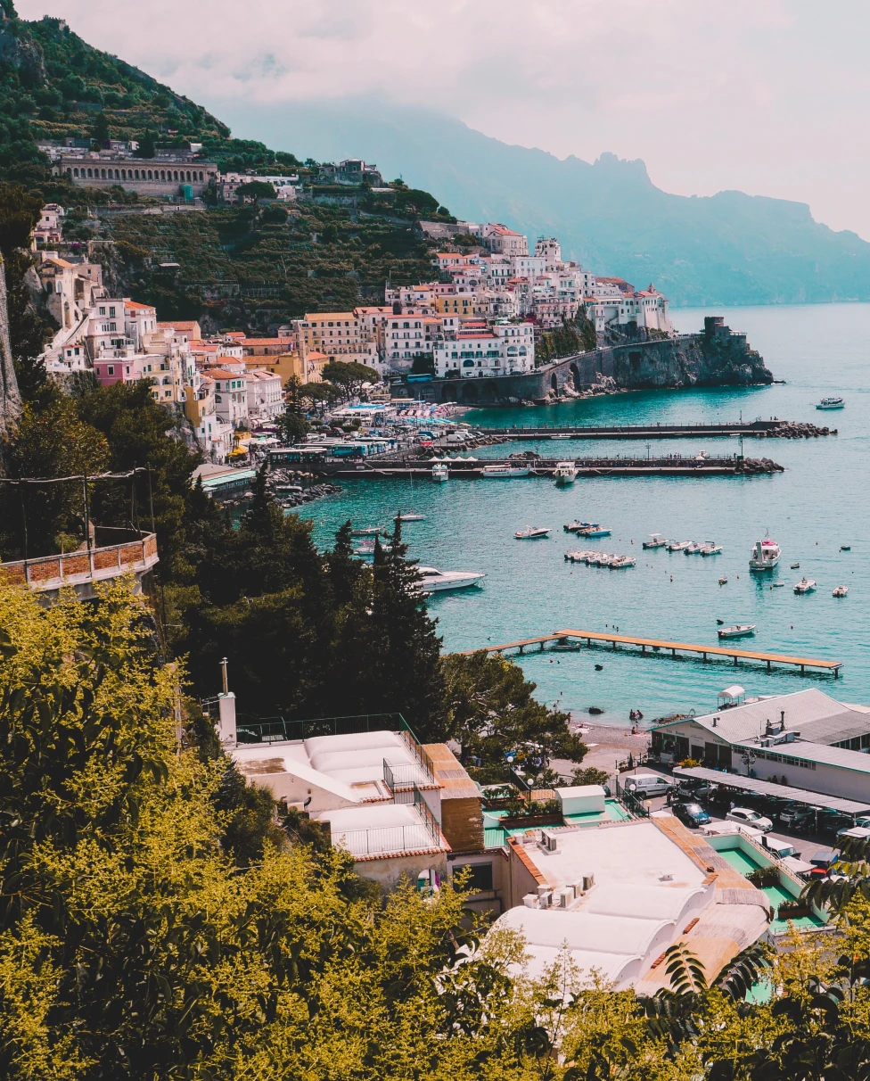 View of blue waters and coastline dotted with colorful buildings in Italy's Amalfi Coast