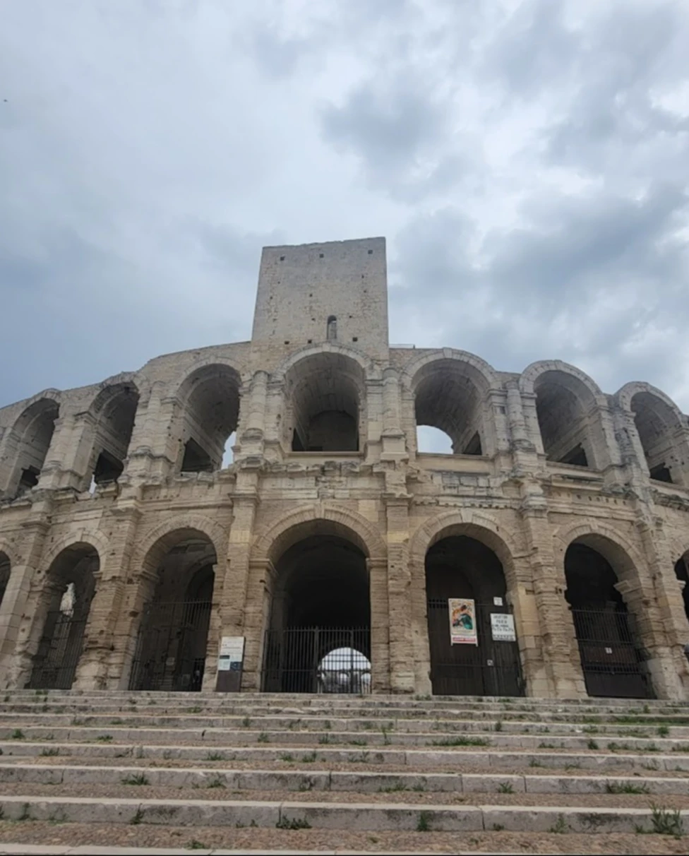 A picture of people standing near an ancient building during the daytime.
