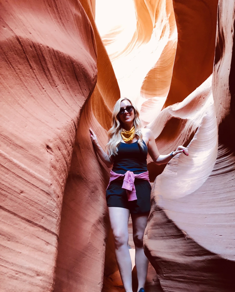 Woman standing between two rocky hills.