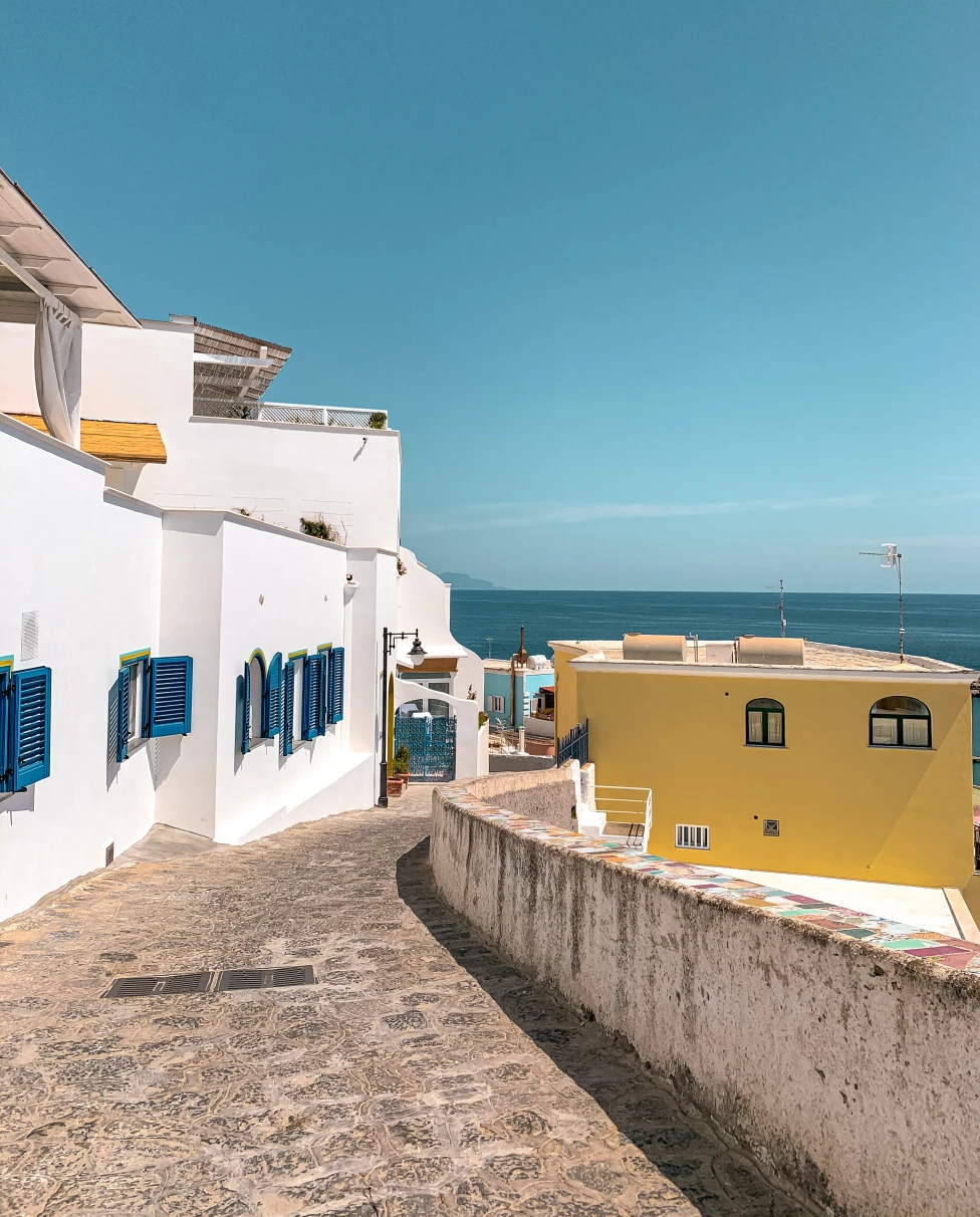 Ischia streets with whitewashed buildings and blue shutters.