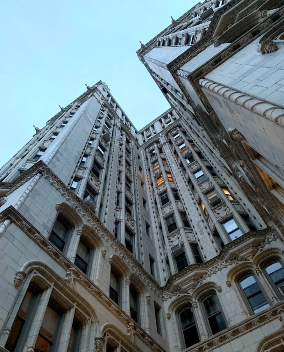 A bottom up view of a stone building with lots of windows in New York City.