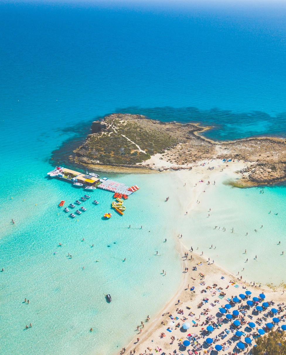 An aerial view of beach with clear blue water